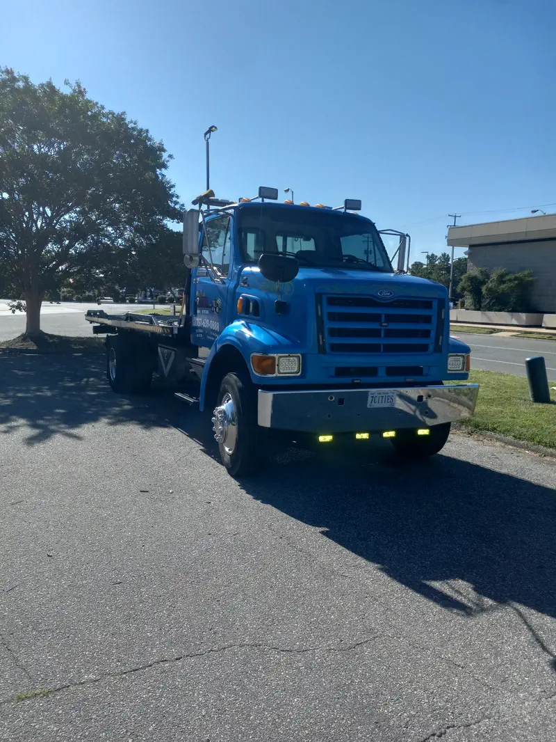 The blue 7 Cities Sterling flatbed parked under an oak tree, bed empty and ready